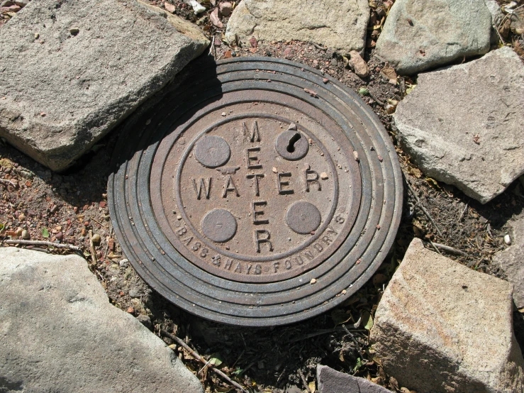 a manhole cover surrounded by bricks and grass