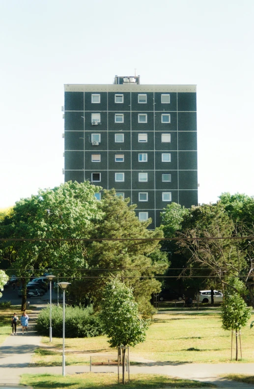 a building in the background with a few people standing in front