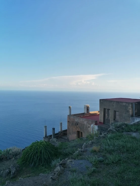 an old run down house overlooking the ocean