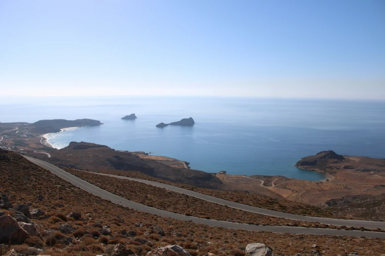 several cars driving down the road to the ocean