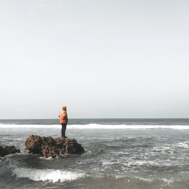 a man standing on the edge of an island with waves