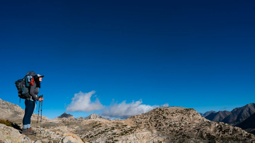 a person on the side of a mountain with a backpack