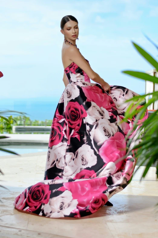 a woman is posing in a long pink dress