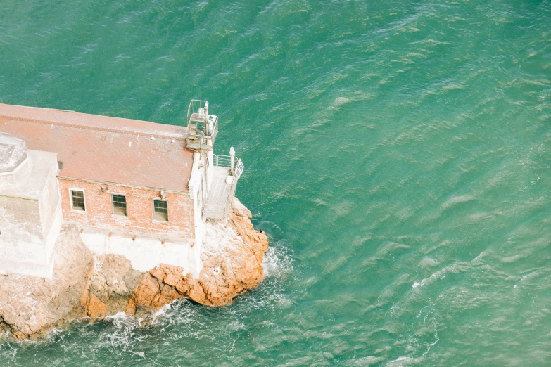 a small brick structure in the ocean with some waves