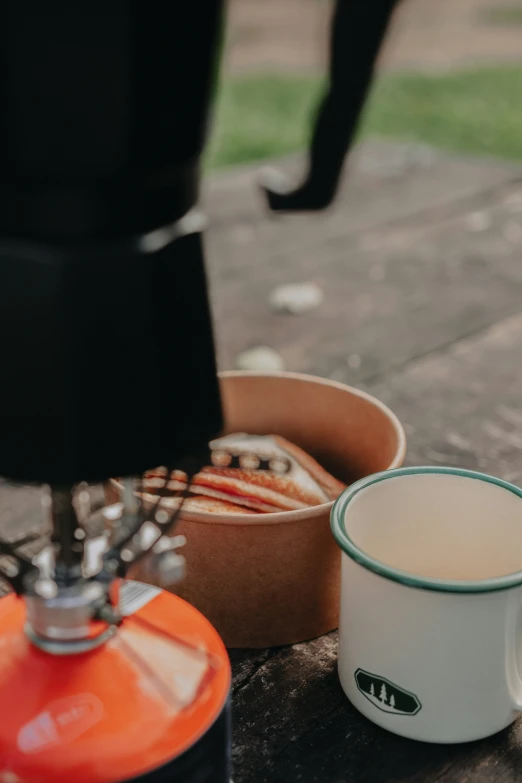 a coffee cup sitting next to two orange chairs
