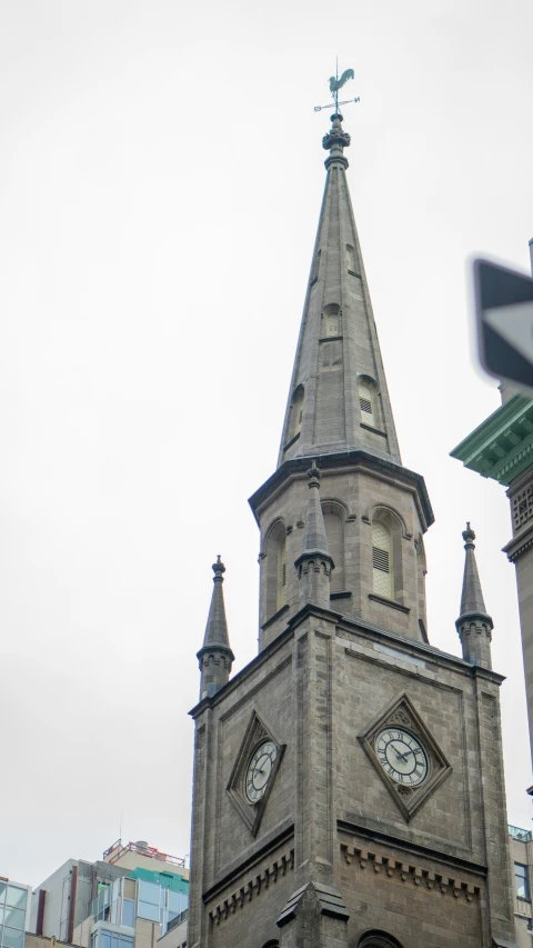 the tower with a steeple and a clock is seen against a white sky