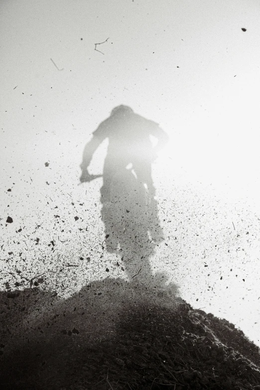 a man riding a skateboard next to a pile of dirt
