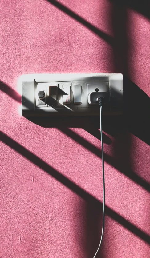 a nintendo wii on pink carpet with electric plugs