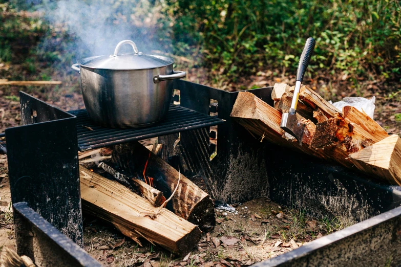 there is wood burning over a pot on a stove