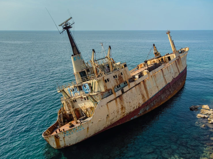 an old boat sits in the ocean on land