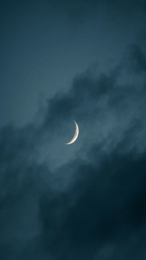 a half - moon is seen in the blue sky