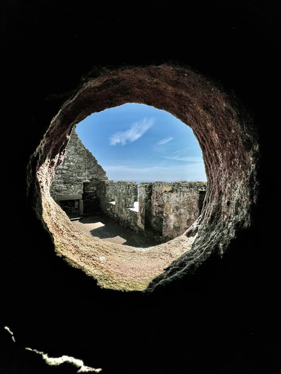 a hole in the ground with trees and sky