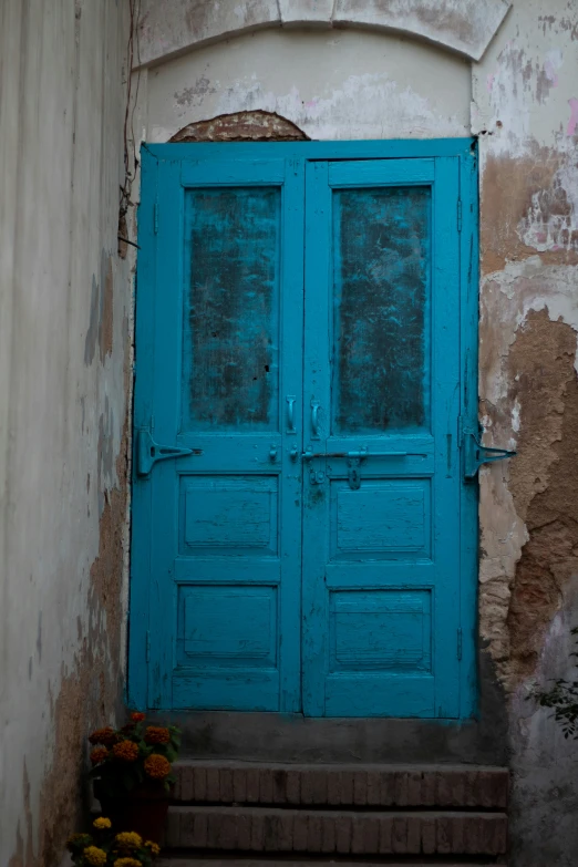 an entrance with two doors painted blue on the outside