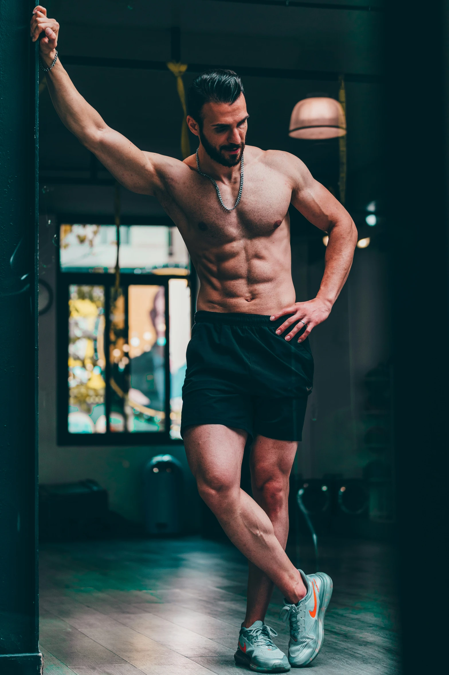 a man without his shirt standing in front of a gym door