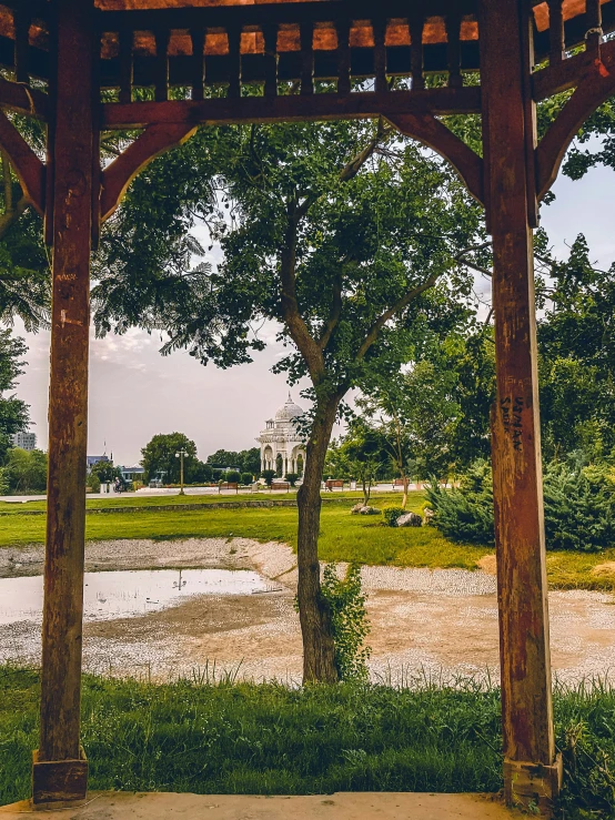 a gazebo with trees inside is shown in the middle of a park