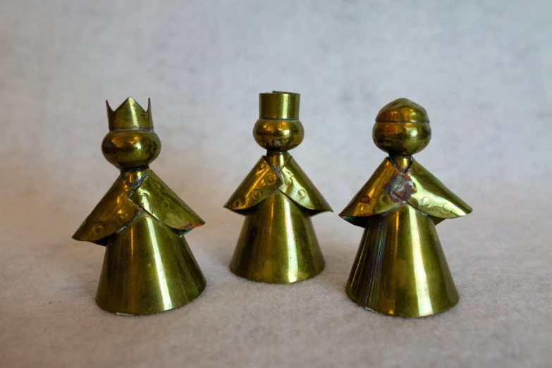 three golden plastic figurines in a line