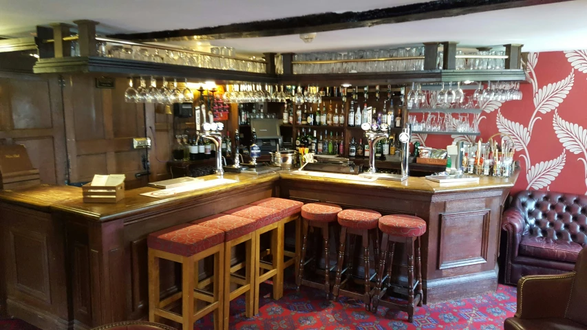 a corner bar with three stools next to it