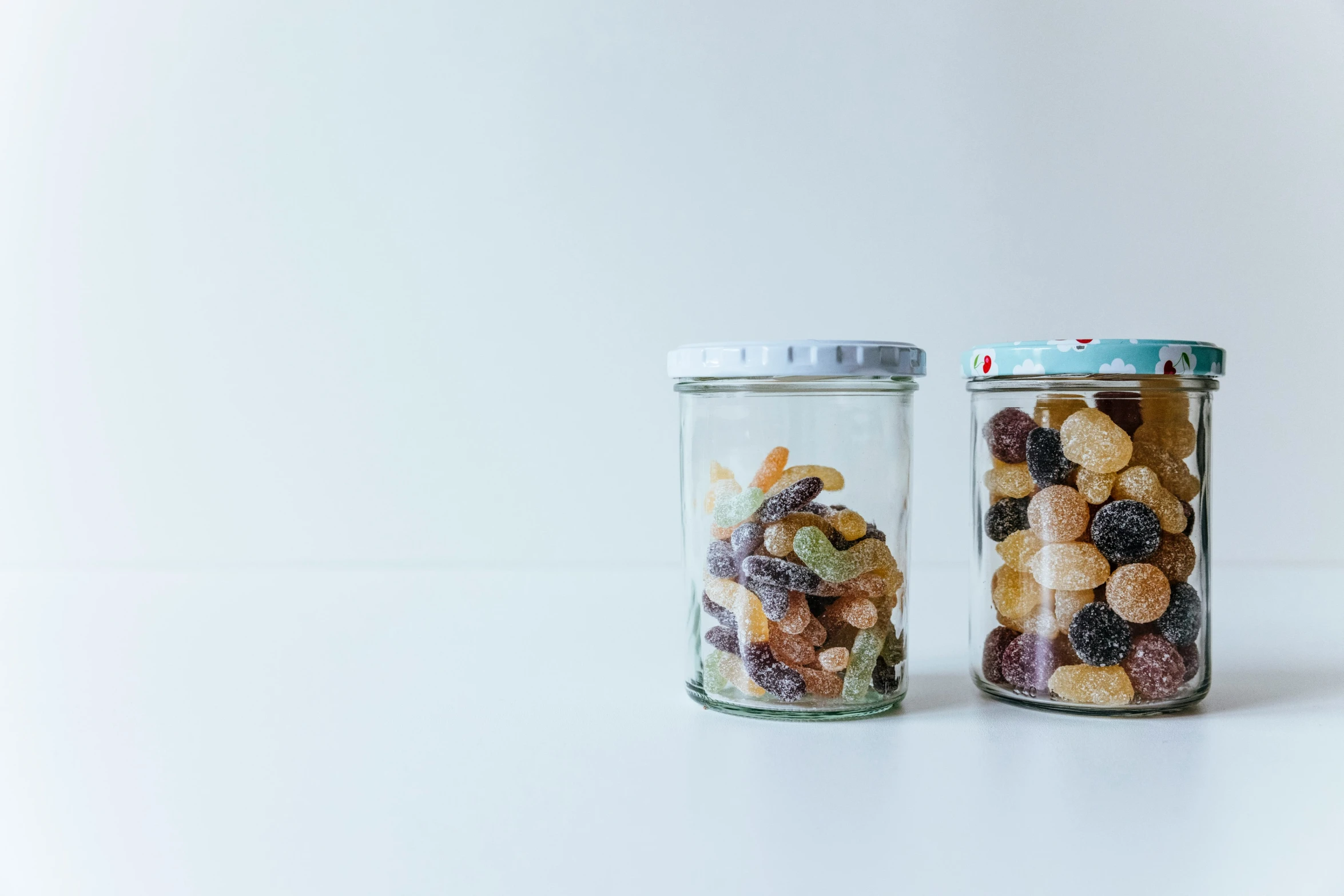 two jars full of mixed cereals sitting on the table