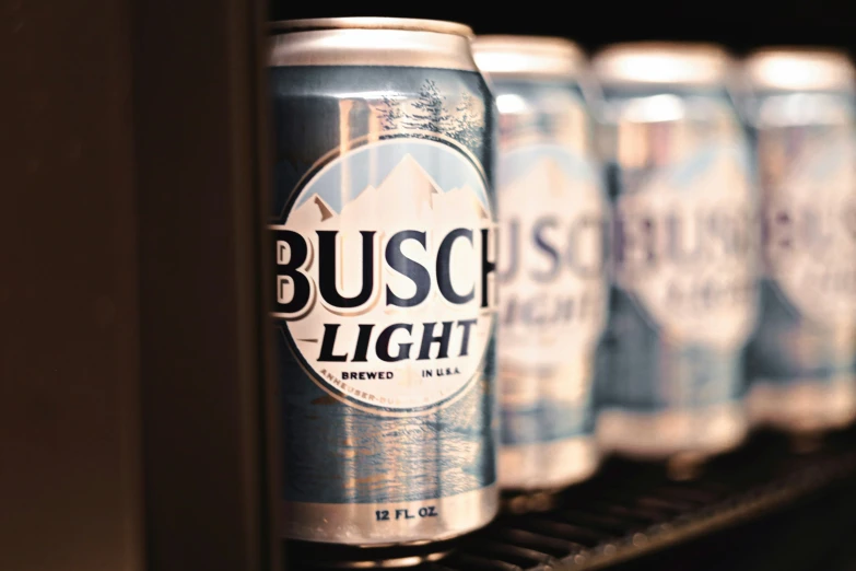 a row of busch light cans sitting on a shelf