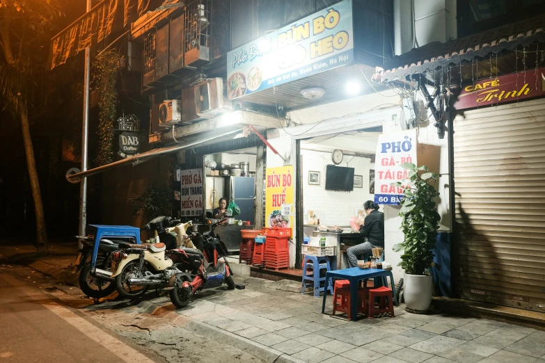 two motorcycles parked in front of a store at night