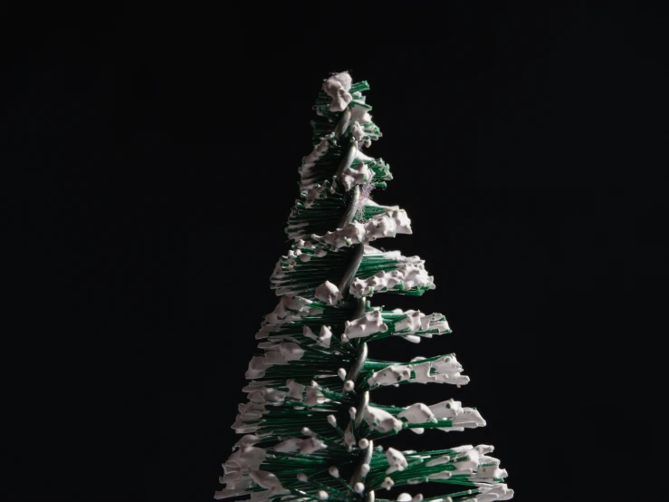 a white and green decorated christmas tree against a dark background