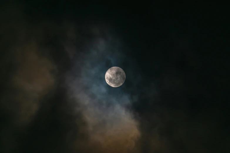 a view of the moon through a dark cloudy sky