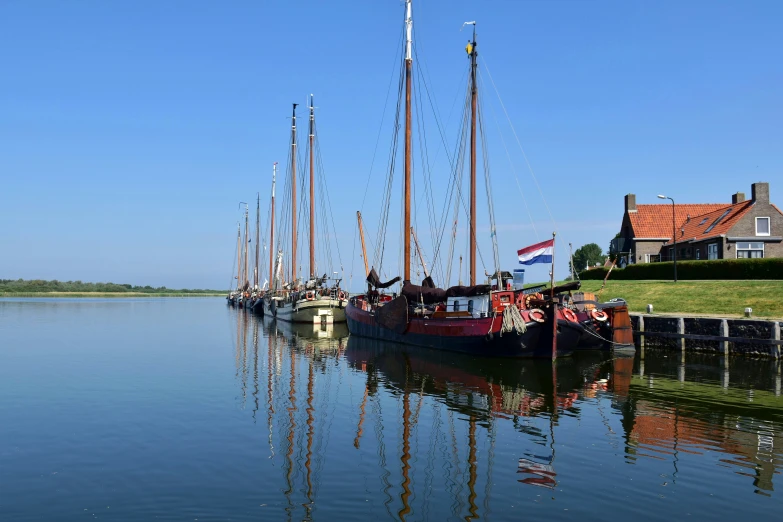 four sail boats in the water on a sunny day