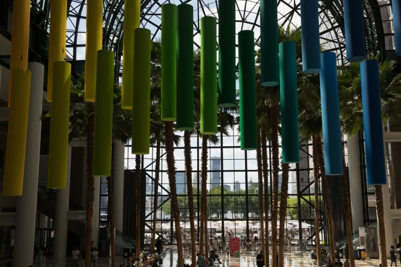 a building that has many colored columns and people walking inside