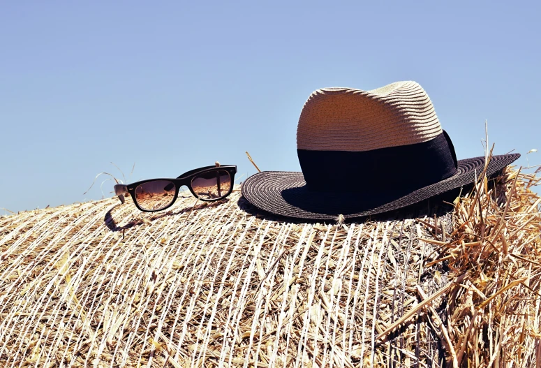 a straw hat with sunglasses on it in the sun