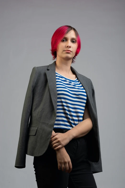a young woman with short pink hair wearing a suit