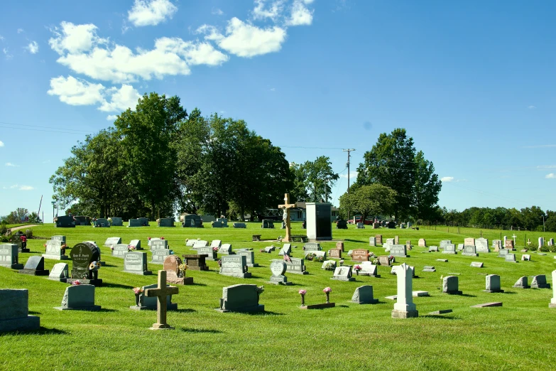 a cemetery with graves and crosses is in the green grass