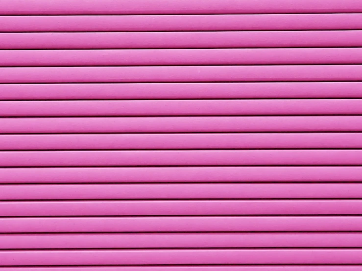 a close up of pink shutters and the side of an apartment building