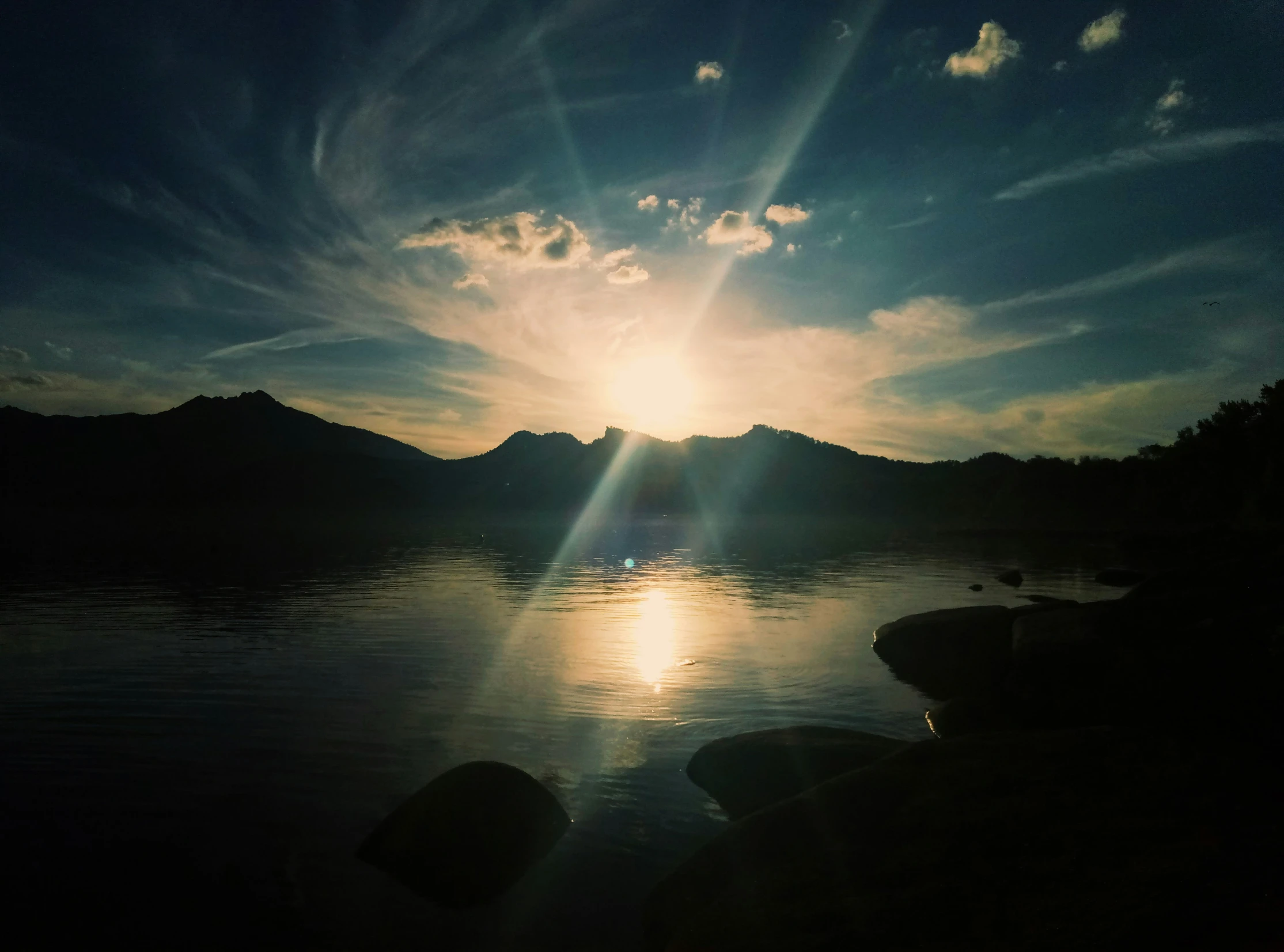 a calm lake with some rocks in it