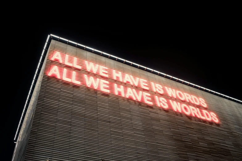 a sign on the side of a building reads, all we have is work, all we have is world