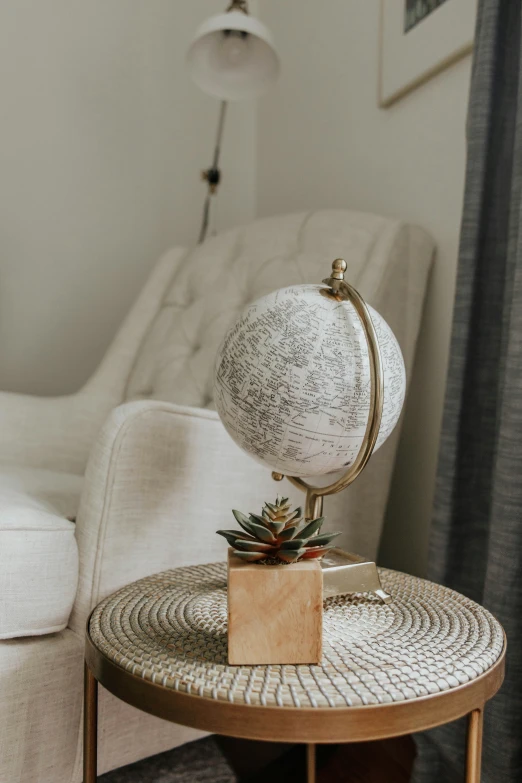 an elegant end table with a globe on it