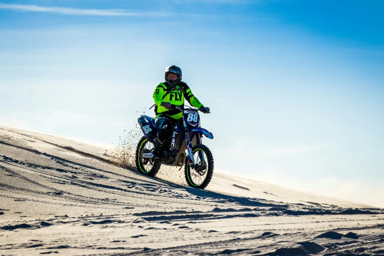 a motorcyclist riding along the top of a snowy mountain