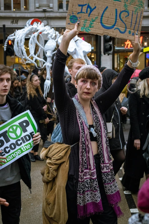 people are standing on a sidewalk holding signs