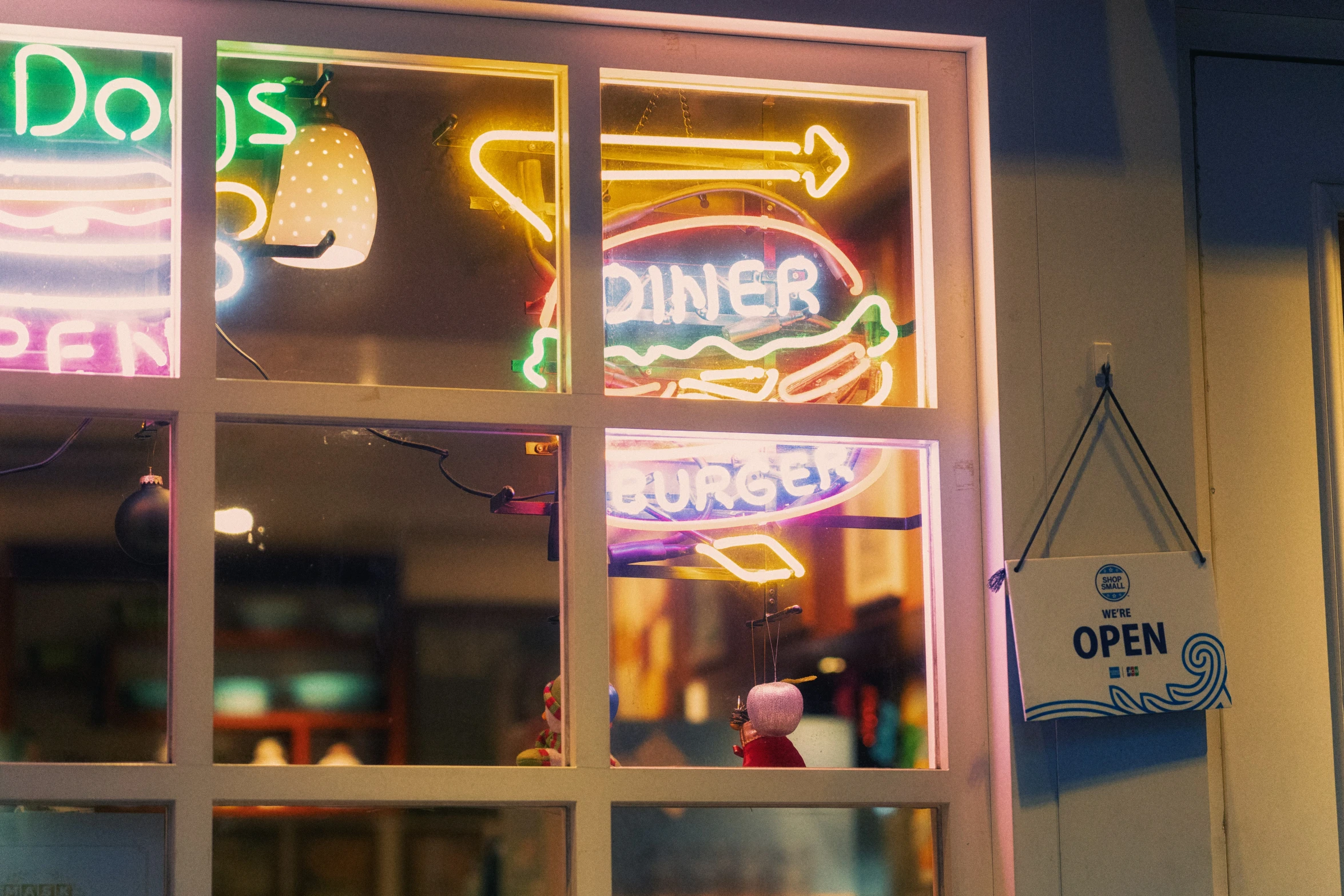 a storefront that has neon signs and signs on the front windows