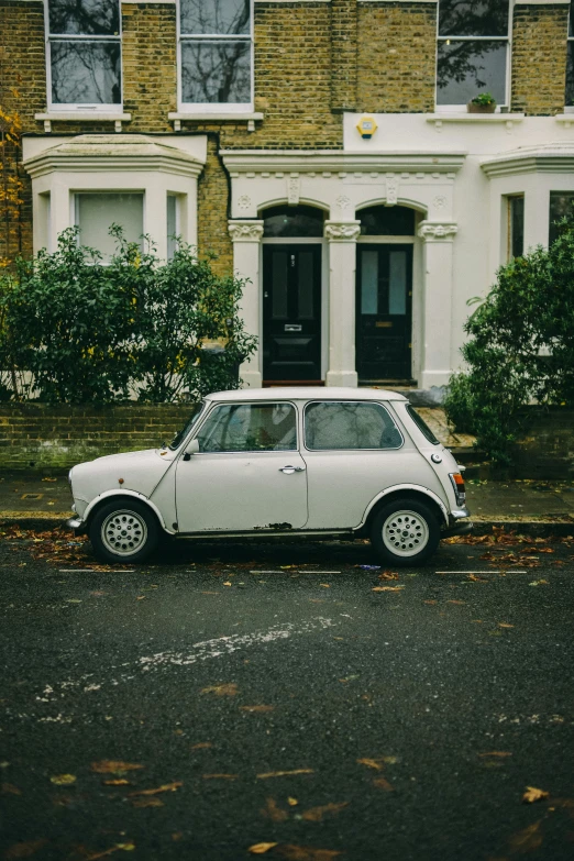 a car is parked near the curb of an old house