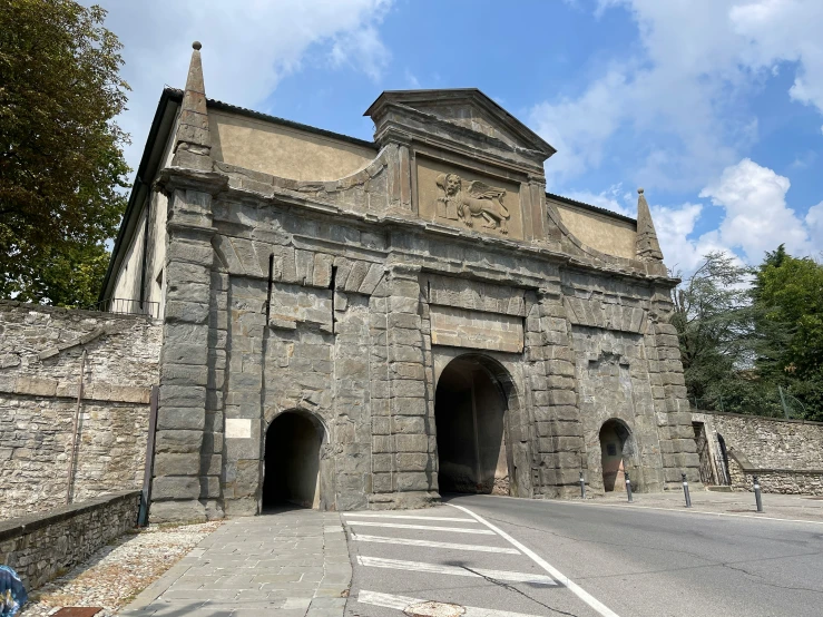 a stone structure sits on the side of a road