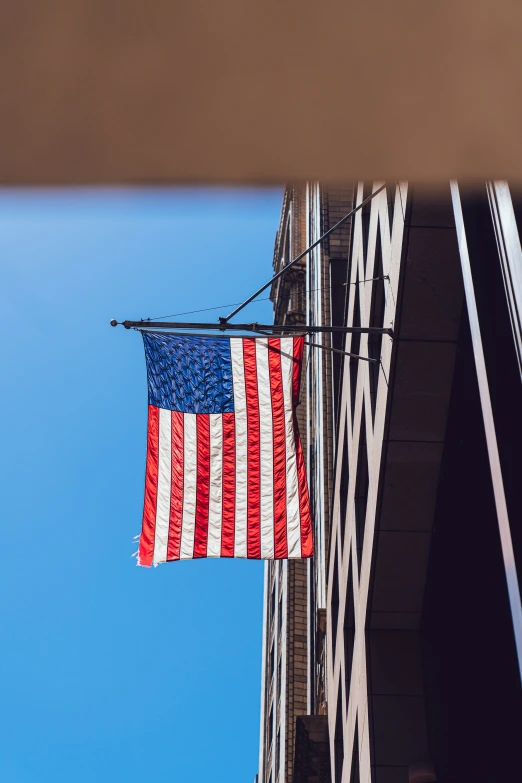 the flag is hanging from the wire near a building