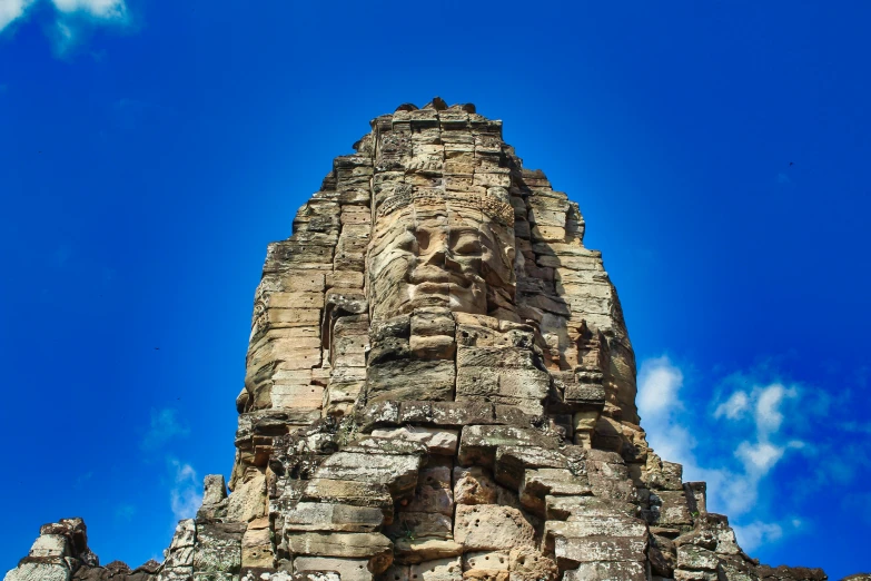 the sky is blue and fluffy above the stone carved face