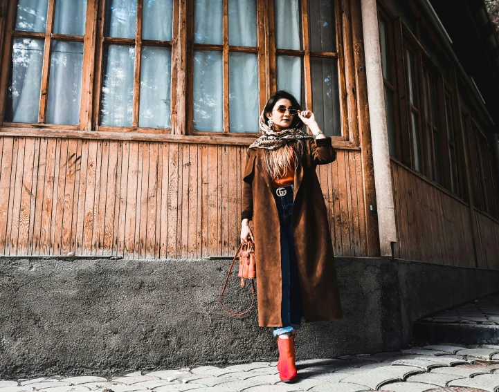 a woman walking on the sidewalk in front of a building