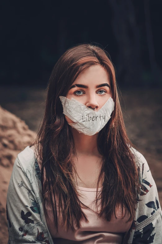 a person wearing a paper face mask with the word liberty taped to it