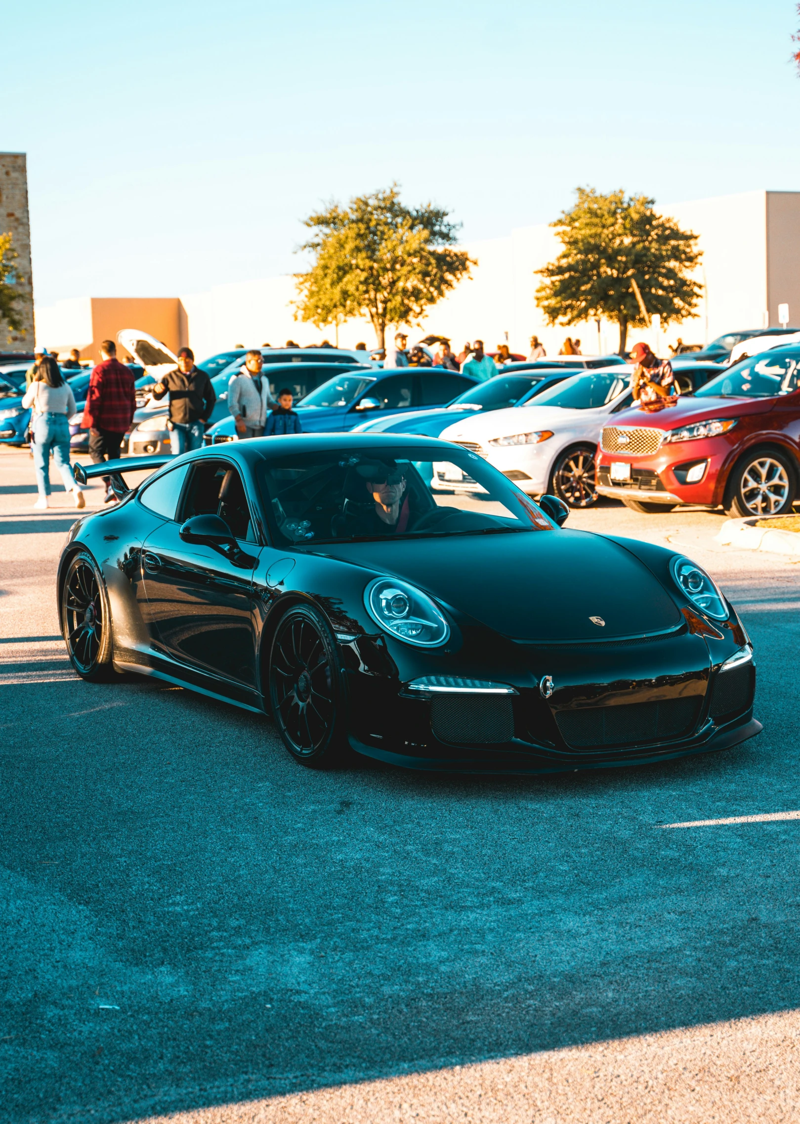 a black sports car sitting next to some parking meters