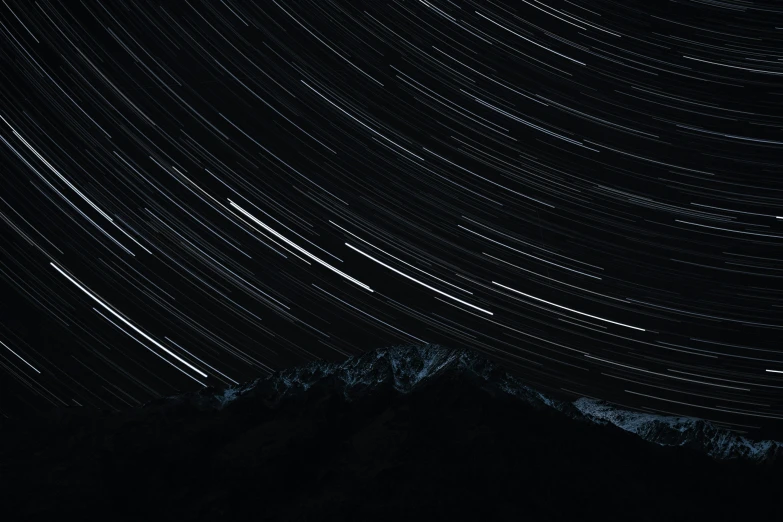 the night sky is dotted with star trails