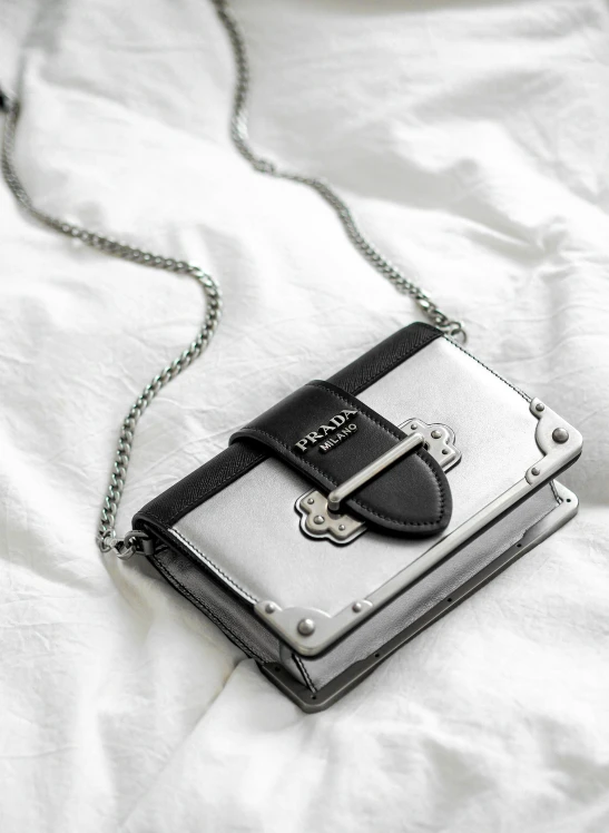 a leather purse on a chain on a white surface