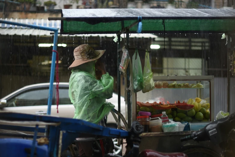 a woman in green shirt standing at an outdoor cart