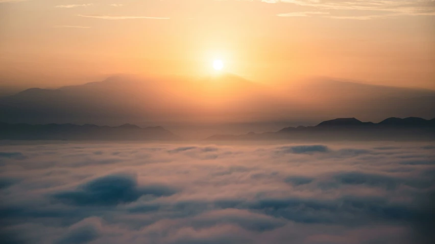 a po taken from the air looking at the sun over the clouds