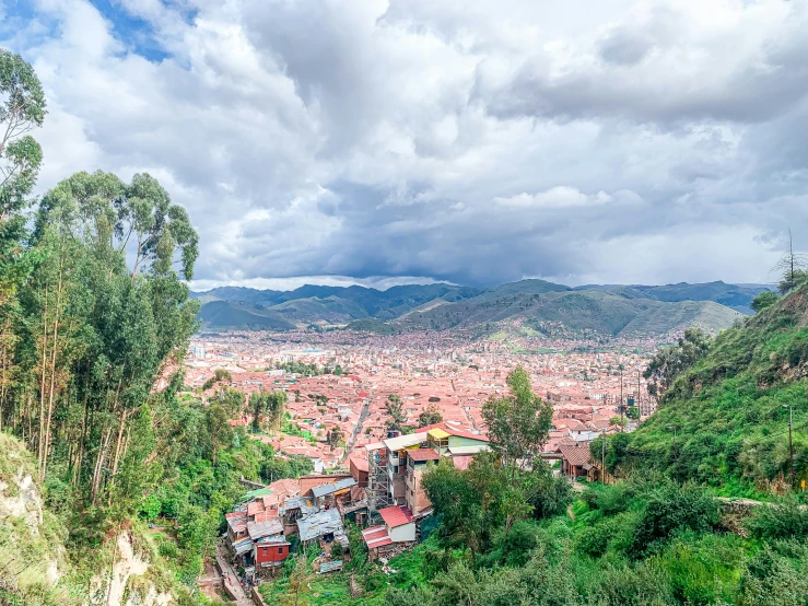 a view from the top of a mountain in a city with hills and houses on each side